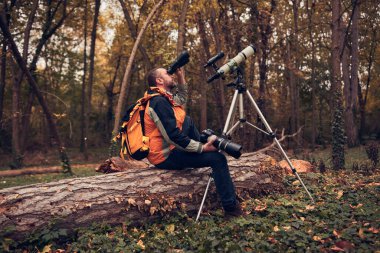 İnsanoğlu doğada kuşları ve hayvanları izlemek için teleskop kullanıyor..