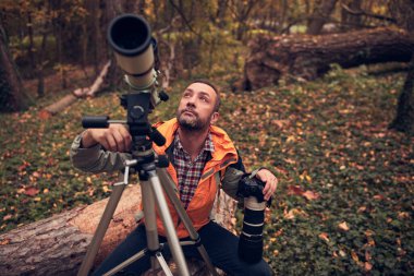 İnsanoğlu doğada kuşları ve hayvanları izlemek için teleskop kullanıyor..