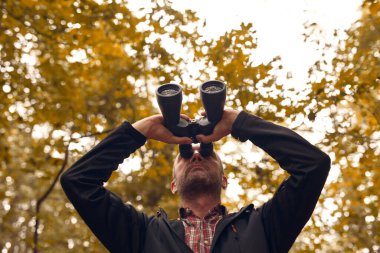 Dürbünü kuşları izlemek için kullanan adam ve diğer gözlemci hayvanlar doğada.