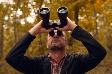 Dürbünü kuşları izlemek için kullanan adam ve diğer gözlemci hayvanlar doğada.
