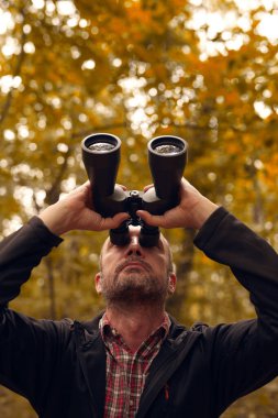 Dürbünü kuşları izlemek için kullanan adam ve diğer gözlemci hayvanlar doğada.