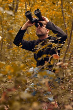 Dürbünü kuşları izlemek için kullanan adam ve diğer gözlemci hayvanlar doğada.