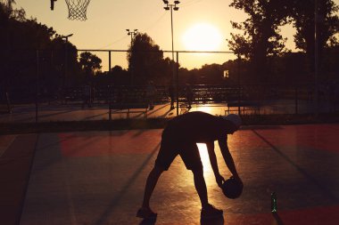 Halk sahasında basketbol topu olan bir adam..