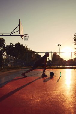 Halk sahasında basketbol topu olan bir adam..