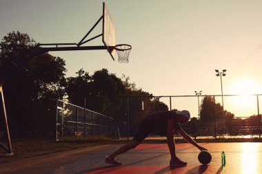 Halk sahasında basketbol topu olan bir adam..