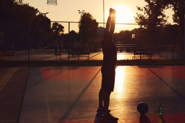 Halk sahasında basketbol topu olan bir adam..