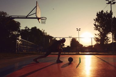 Halk sahasında basketbol topu olan bir adam..