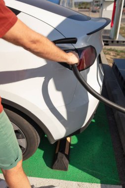 Kamu şarj aletine elektrik yükleyen adam..