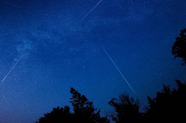 Perseid meteor yağmuru, Samanyolu yıldızları ve manzara siluetleri.