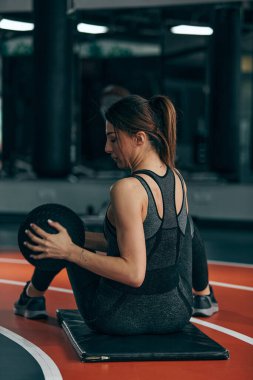 Sportif bir bayan bir topla spor salonunda çalışıyor..