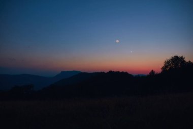 Hilal Ay, gezegen birleşimi ve manzara siluetleri.