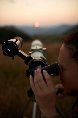 Dişi astronom teleskopla güneşe bakıyor..