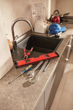 Mutfak lavabosundaki musluğu tamir etmek ve onarmak için boru aletleri..