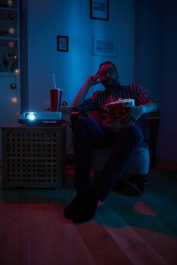 Adam evde film izlerken patlamış mısır ve meyve suyu içiyor..