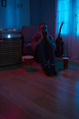 Adam evde film izlerken patlamış mısır ve meyve suyu içiyor..