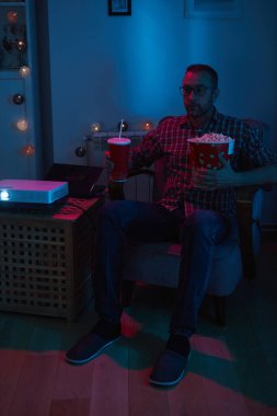 Adam evde film izlerken patlamış mısır ve meyve suyu içiyor..