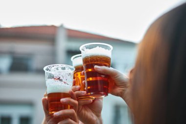 Bir grup arkadaş arka bahçe partisinde soğuk biranın tadını çıkarıyor..