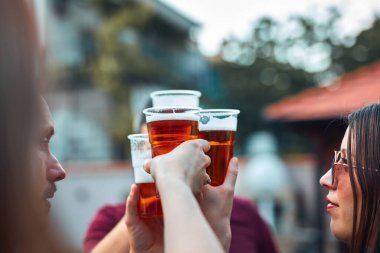 Bir grup arkadaş arka bahçe partisinde soğuk biranın tadını çıkarıyor..