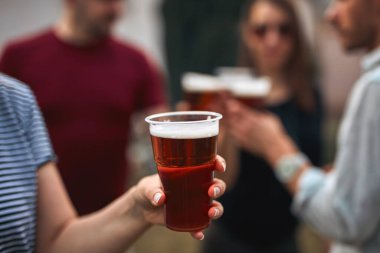 Bir grup arkadaş arka bahçe partisinde soğuk biranın tadını çıkarıyor..