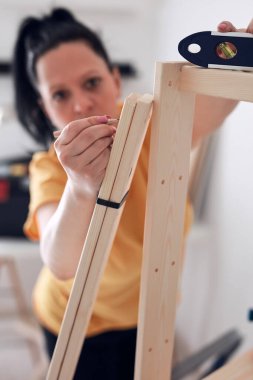 Yeni ahşap raf ve mobilyaları bir araya getiren kadın..