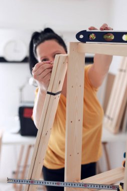 Yeni ahşap raf ve mobilyaları bir araya getiren kadın..