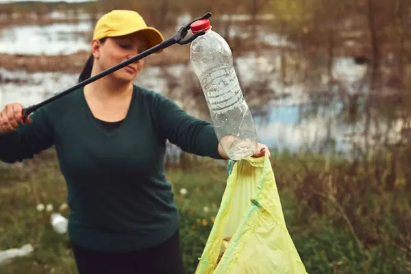 stock image Volunteer and environmental activist cleaning dirty lake shore filled with trash.