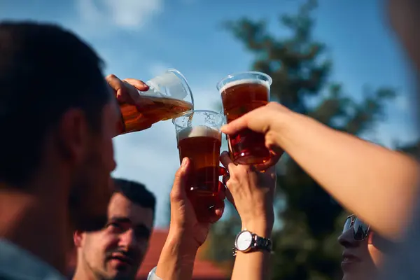 Group of friends enjoying cold beer at a backyard party.