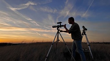 Güneş tutulması ve Güneş 'i teleskop ve özel güneş filtresiyle gözlemleyen amatör astronom..