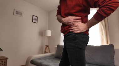 Kalçası, sırtı ve siyatik ağrısı olan bir adam..