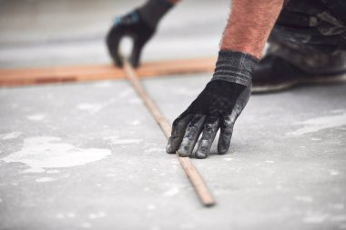 Profesyonel tamirci yeni bir daireye kaplama döşeme kuruyor..