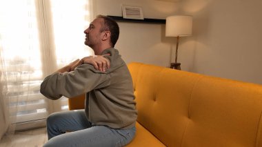 Evinde omuz ağrısı olan bir adam..