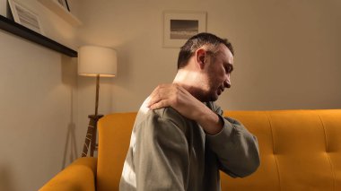 Evinde omuz ağrısı olan bir adam..