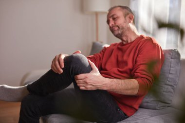 Evinde diz ağrısı olan bir adam..