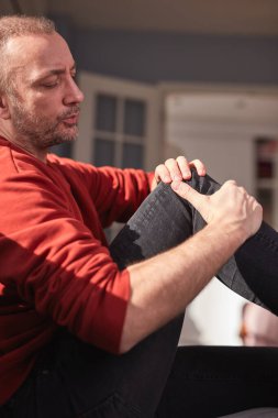 Evinde diz ağrısı olan bir adam..