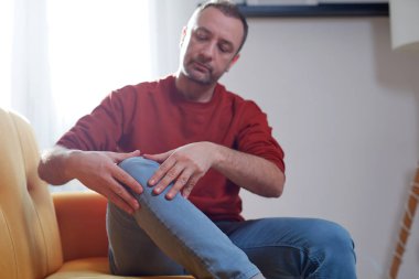 Evinde diz ağrısı olan bir adam..