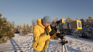 Amatör astronom özel güneş filtresiyle güneşe teleskopla bakıyor..