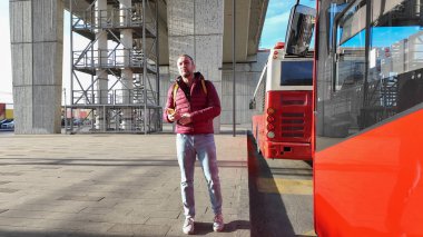 Şehir istasyonunda otobüs bekleyen bir yolcu..