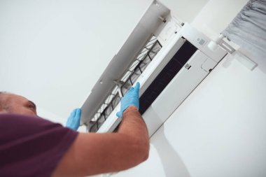 Evdeki havalandırmayı temizleyen ve koruyan adam..