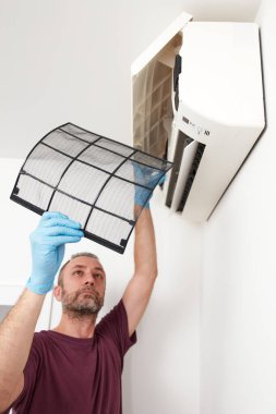 Evdeki havalandırmayı temizleyen ve koruyan adam..