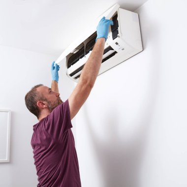 Evdeki havalandırmayı temizleyen ve koruyan adam..