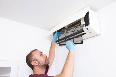 Evdeki havalandırmayı temizleyen ve koruyan adam..