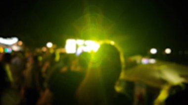 Sahne ışıkları olan, bulanık fotoğraflı konser kalabalığının siluetleri.