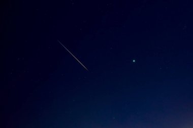 Samanyolu yıldızlarının ve meteor izlerinin fotoğrafı.