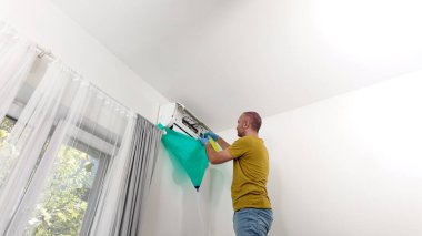 Man 'ın evdeki havalandırma ünitesini temizleyen ve koruyan adam..