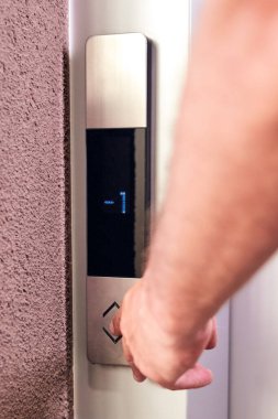 Binadaki asansör düğmelerine basan kişi.