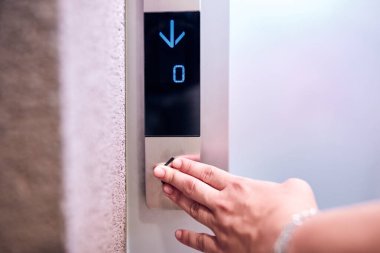 Binadaki asansör düğmelerine basan kişi.