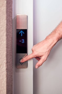 Binadaki asansör düğmelerine basan kişi.