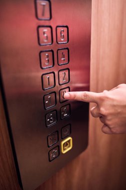 Binadaki asansör düğmelerine basan kişi.