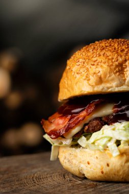 Pastırmalı, peynirli ve marullu bir hamburgerin fotoğrafını çek.