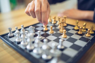 Satranç hamlesi yapan biriyle stratejik düşüncelere dalmak, altın ve gümüşe odaklanmak. İş stratejisi başarı kavramı.